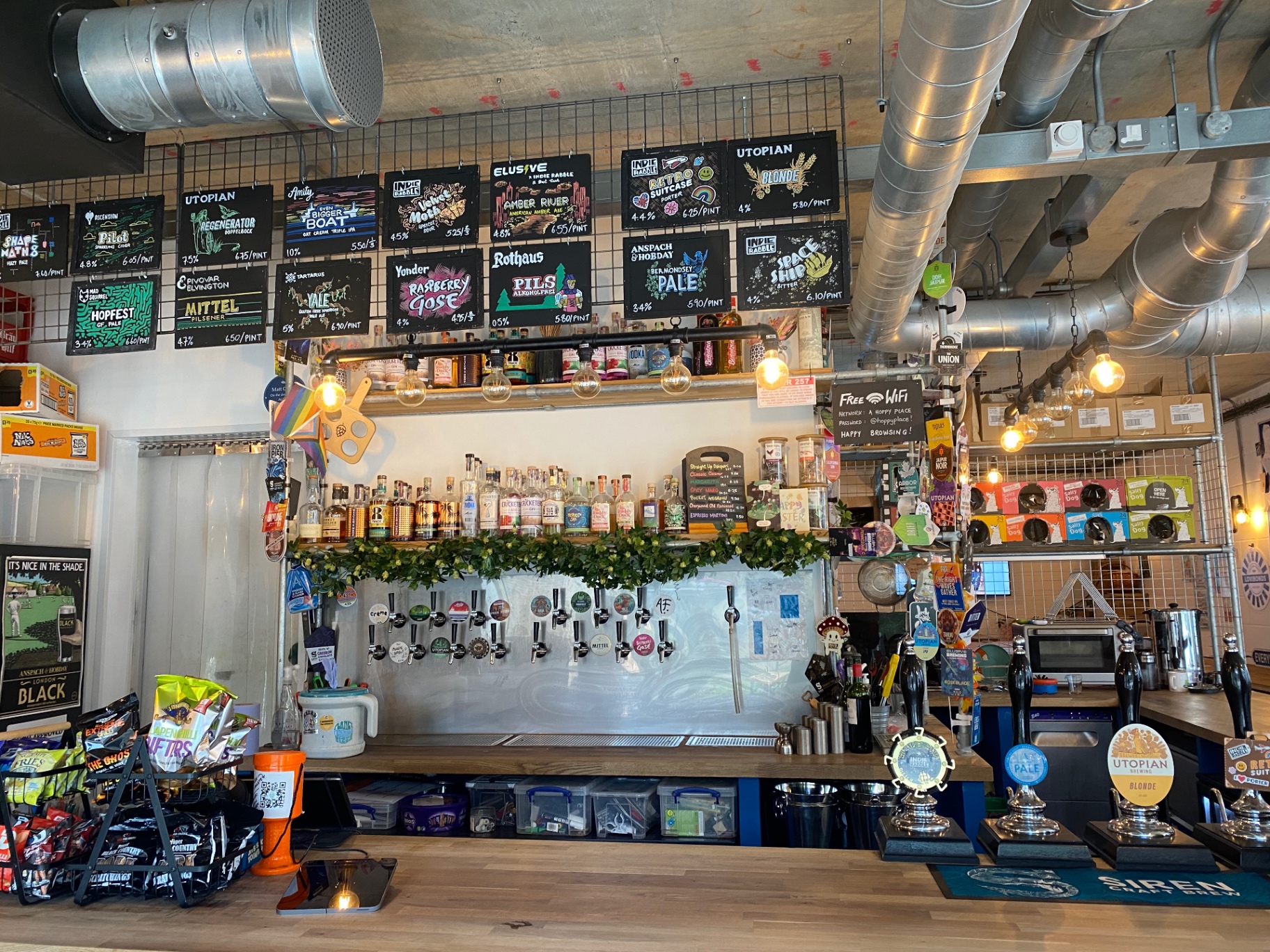 The bar at A Hoppy Place with the tap list chalkboards above